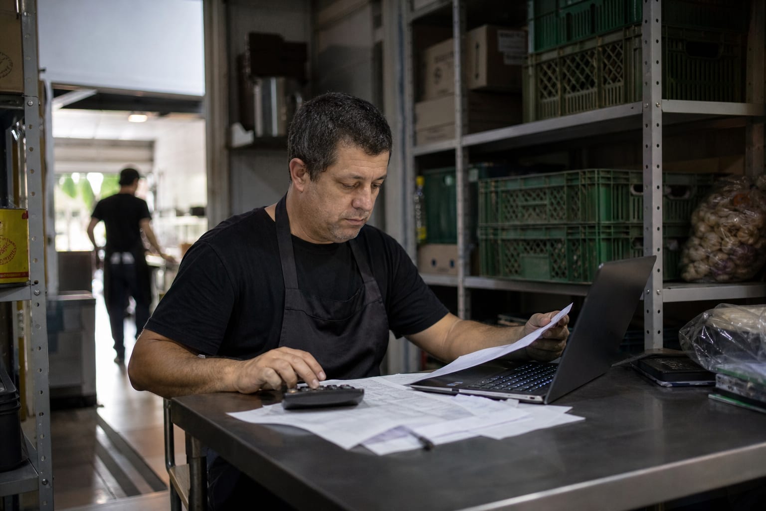 Dono de restaurante fazendo contas no escritório dos fundos da casa